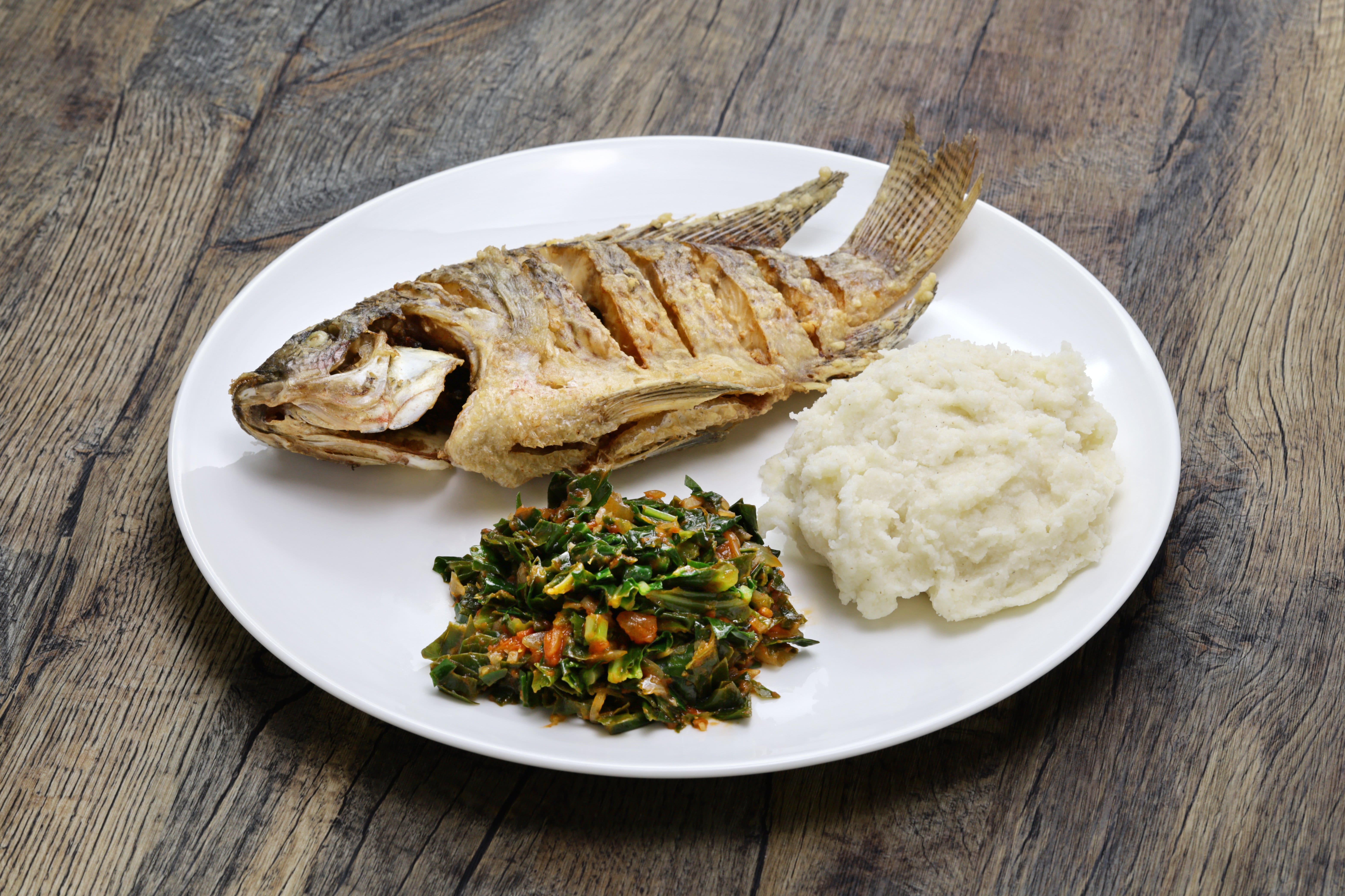 fried fish(Tilapia), ugali(white maize flour mash) and Sukuma Wiki(kale stew), Kenyan food